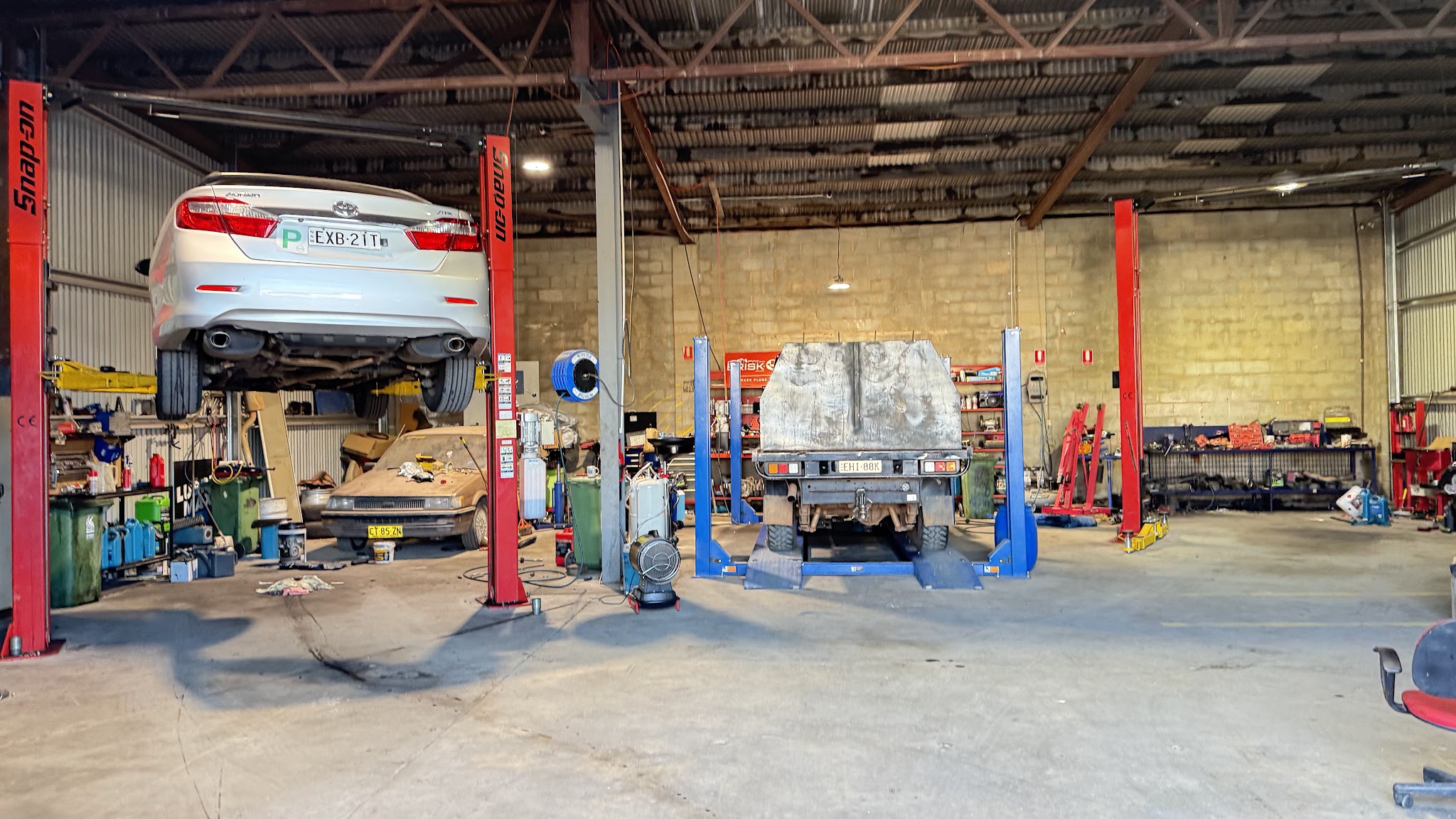 Inside the R/T Automotive workshop in Ashmont, cars up on the hoists